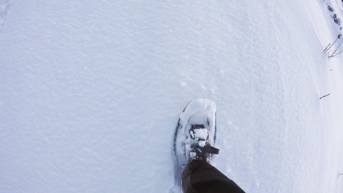 走在高山野地的白色雪地小道上