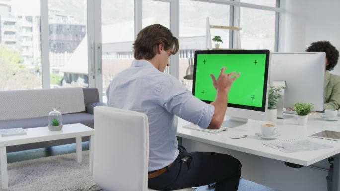 一个年轻商人在使用绿屏电脑