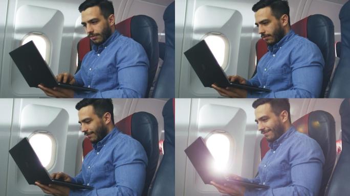 男子在飞机上拿着笔记本电脑工作