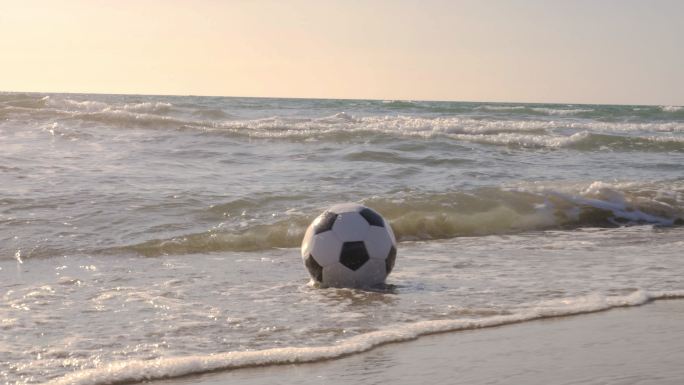 海浪拍打在沙滩上的足球