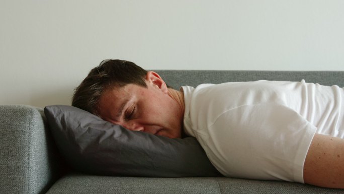 沮丧的男人睡在枕头上翻身的画像