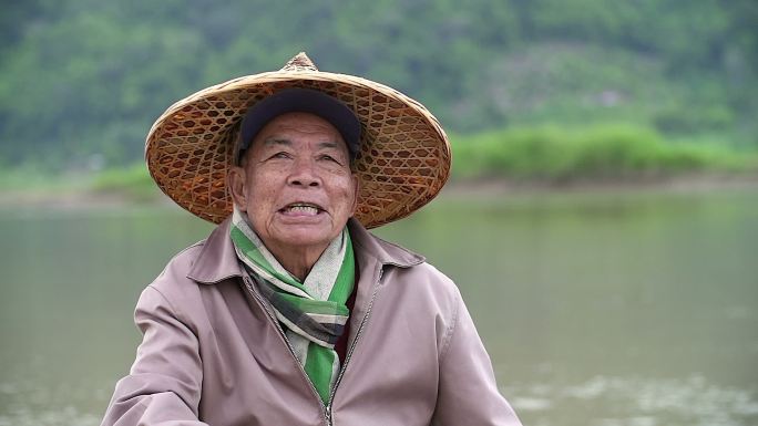 快乐的老渔夫笑脸坐在河边的画像。