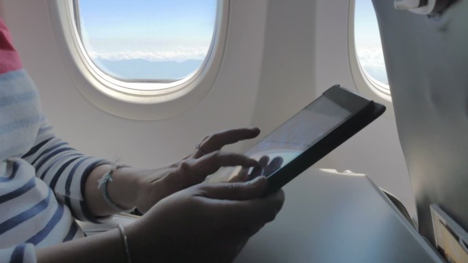 在飞机上使用数字平板电脑的手