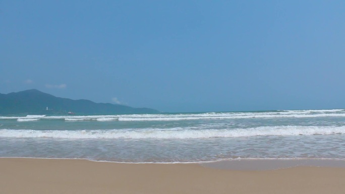 海边浪花拍打在沙滩上