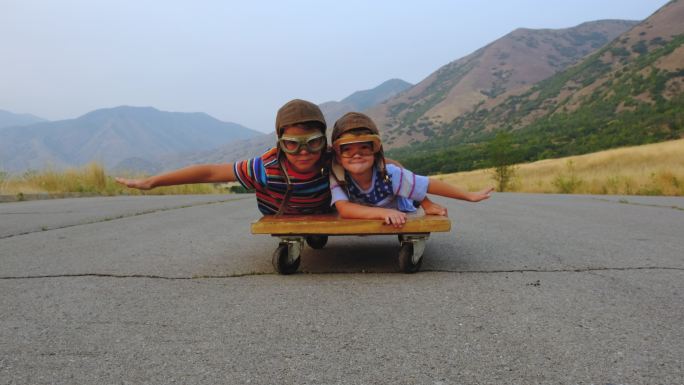 躺在滑板的两个小孩子
