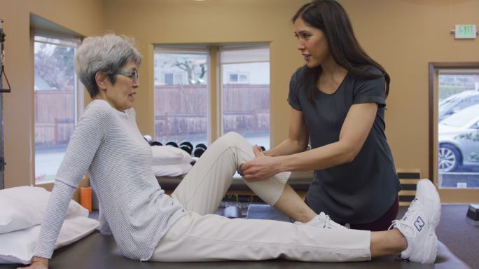 理疗师按摩老年女性小腿肌肉