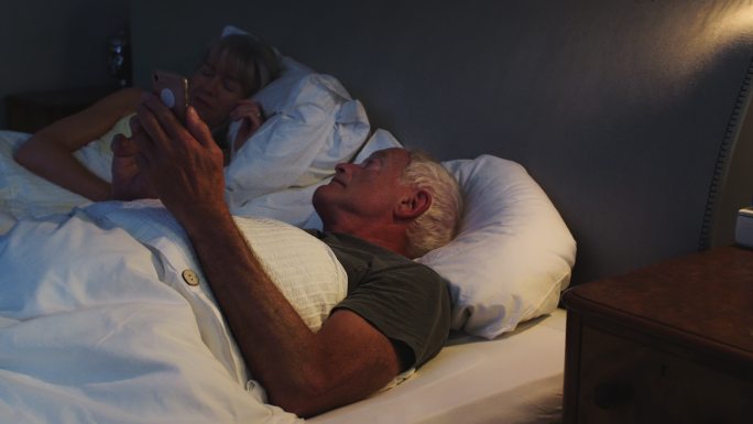 在床上使用手机的老人