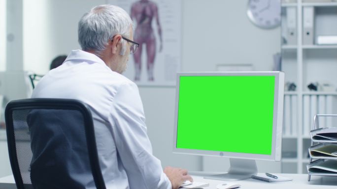 在使用绿屏电脑工作的医生