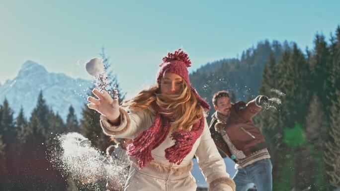 一个年轻的妇女朝着相机扔雪球