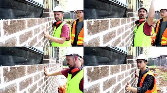 建筑工人教受训者砌砖。
