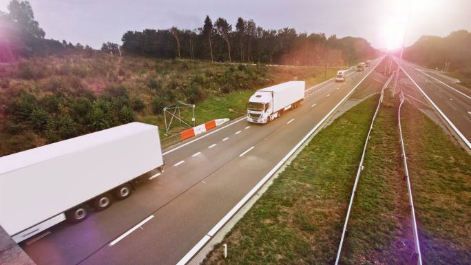 带拖车的商用卡车驶过空旷的公路