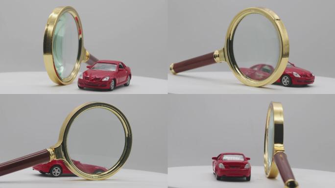 一辆红色汽车在魔方下面、放大镜前面旋转