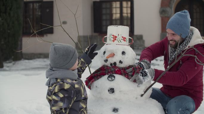 陪孩子一起堆雪人的父亲