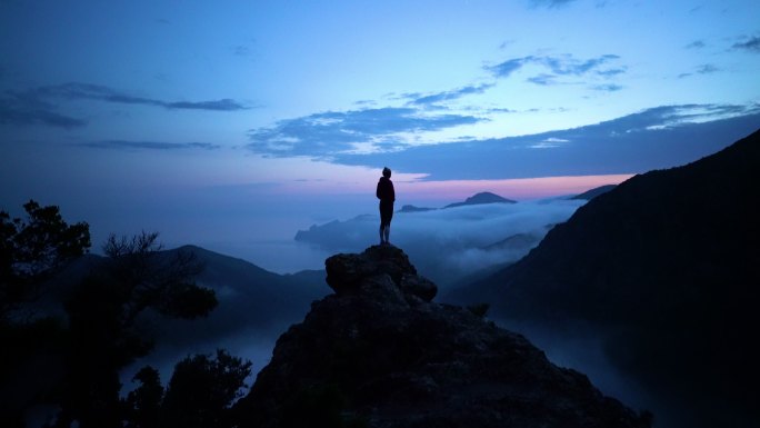 悬崖上的人山顶剪影山峰