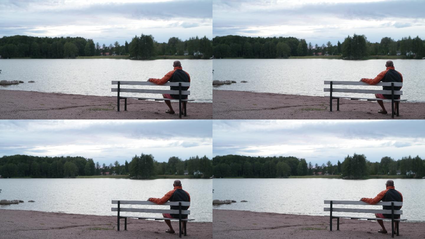 坐在湖边长凳上的老人