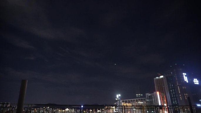 城市夜空中的月亮和航行的飞机