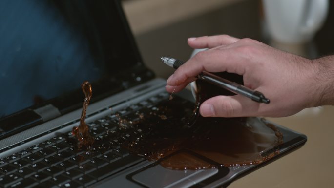 咖啡洒在笔记本电脑上慢动作