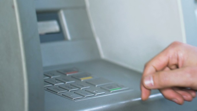 手在ATM机上输入密码