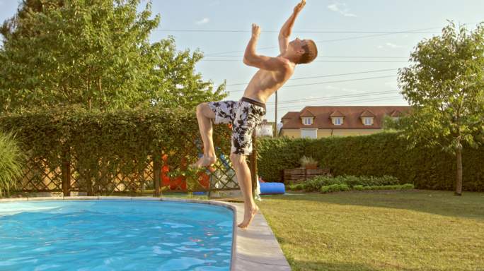 一个年轻人用后空翻跳进游泳池