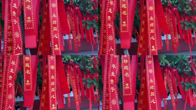 寺庙树枝上悬挂的红底黄字的许愿条