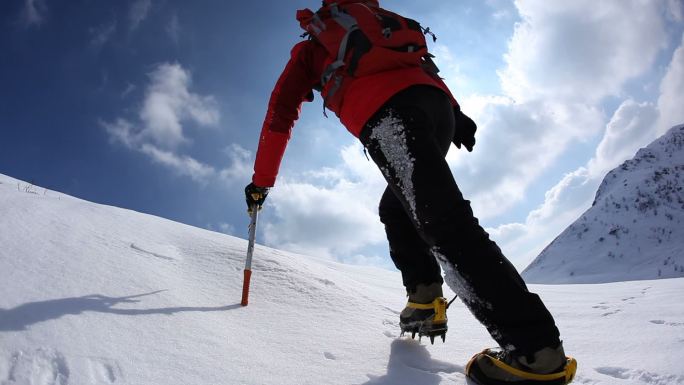 沿着雪坡上山的登山者