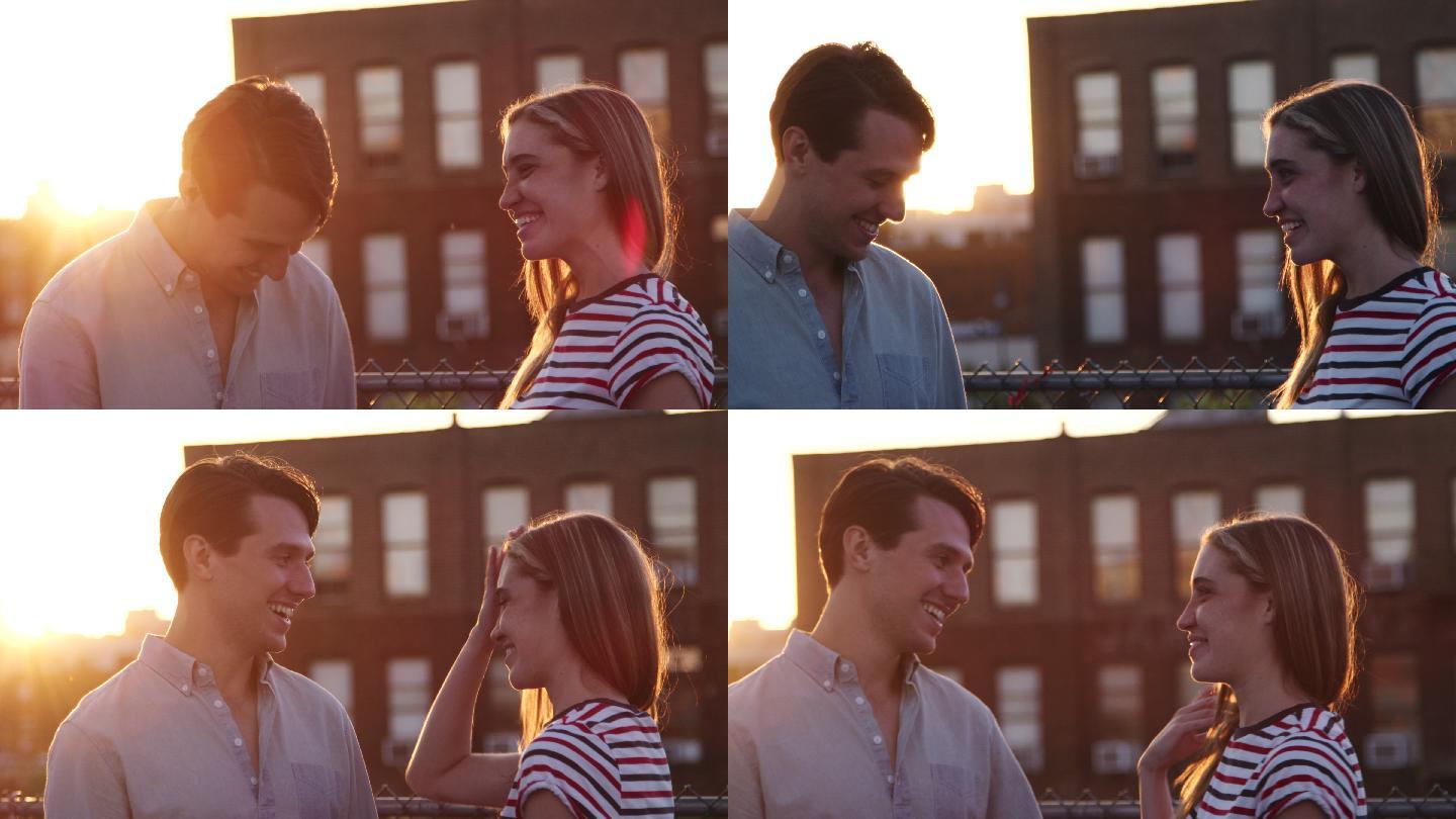 日落时分，一对年轻夫妇在屋顶上交谈