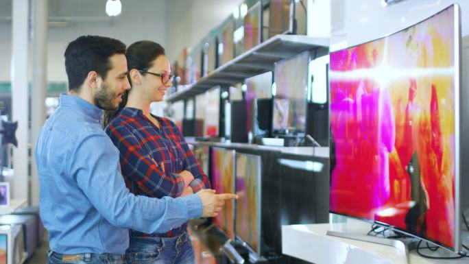 一对夫妇在商店选购一台新的电视机。