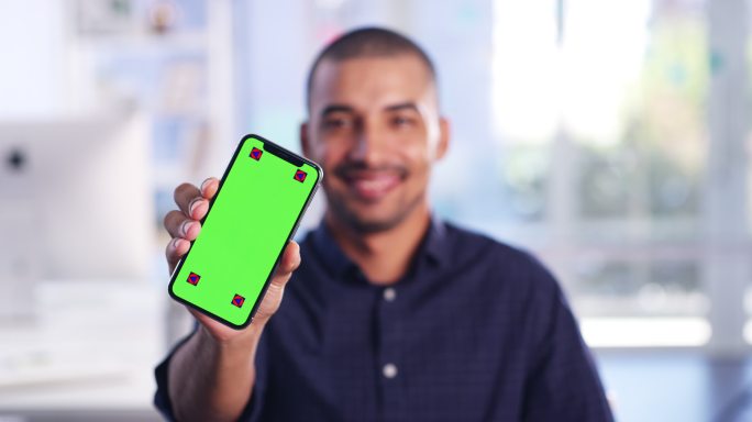 年轻人拿着一部绿色屏幕的手机