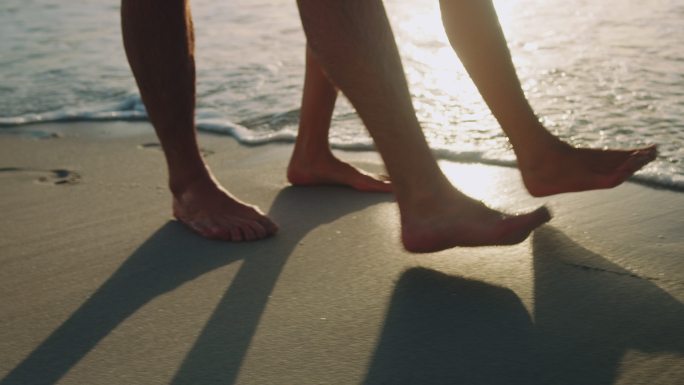 在海滩散步的情侣脚步散心幽会海岸线海浪比