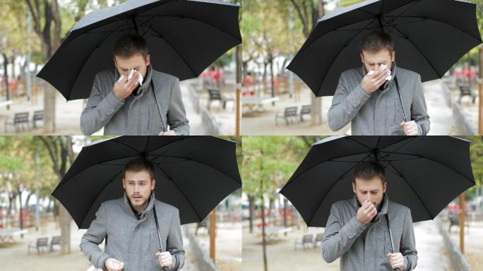 打喷嚏的男人在雨中行走