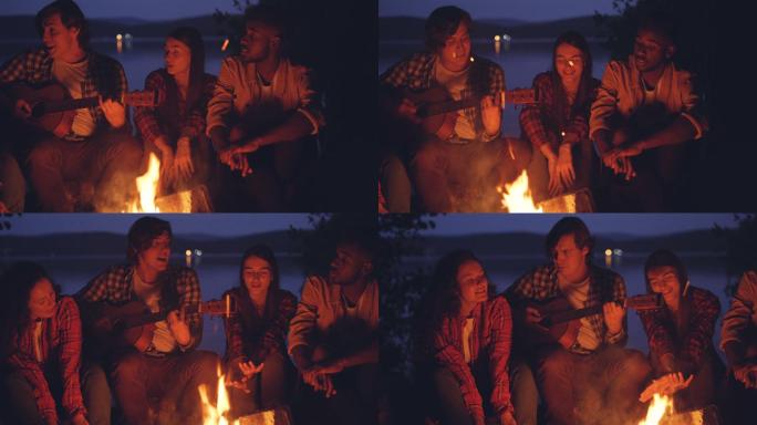 快乐的朋友们围着炉火边唱歌边弹吉他
