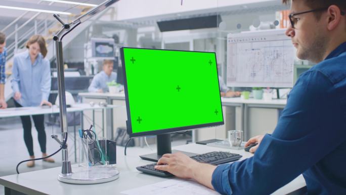 工程师在绿色模拟屏幕桌面电脑工作