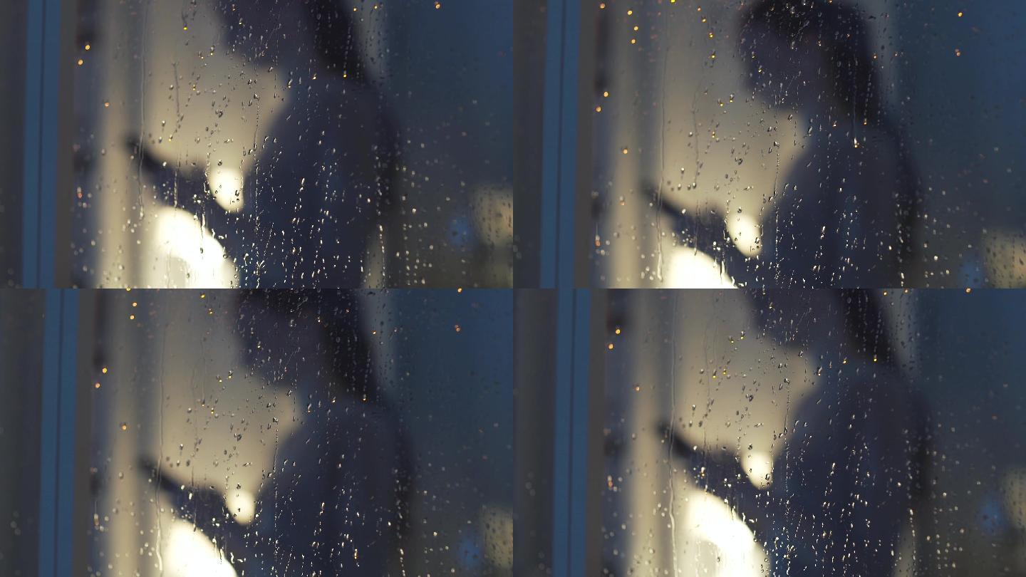 雨夜在窗户旁边用手机的女人