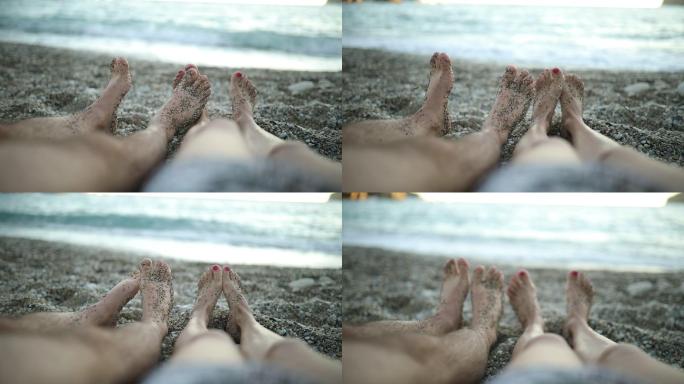 日落时躺在海滩上的脚部特写