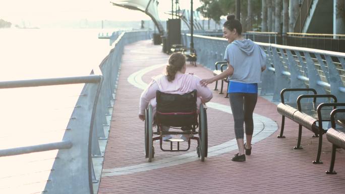坐在轮椅上和朋友在城市里散步