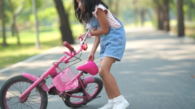 推起自行车的小女孩