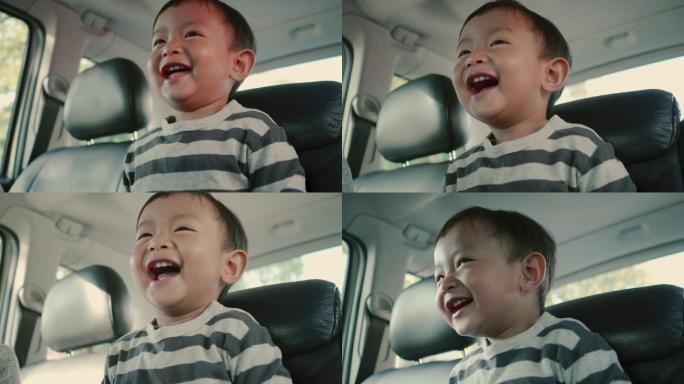小男婴在旅途中笑着坐在汽车后座上