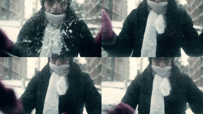 女人带着手套清除车窗上的雪