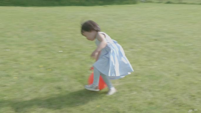 小女孩在夏日乡村花园玩皮球