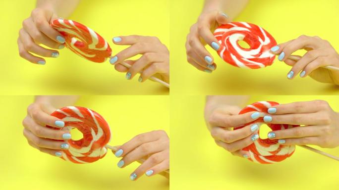 大的彩色棒棒糖在女性手中移动。