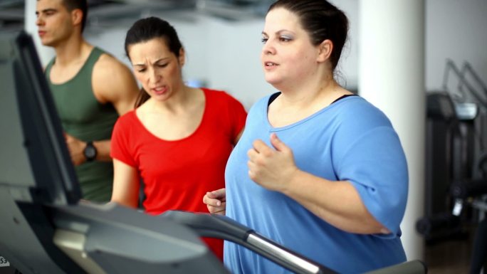 在跑步机上锻炼的超重妇女。