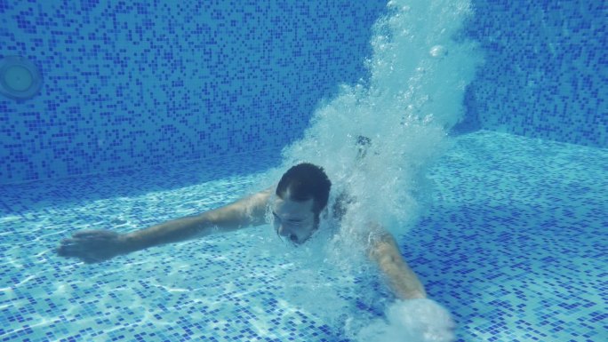 跳进游泳池的男人跳水夏季休闲度假