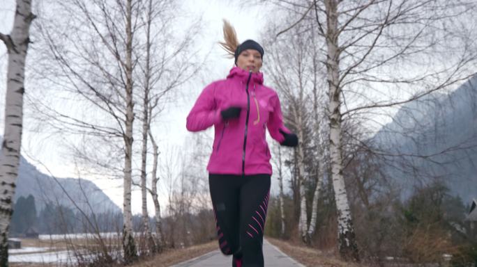 林间奔跑的女人晨跑运动健康生活公园锻炼