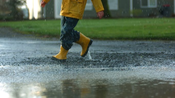 孩子跳进水坑升格慢镜头下雨小孩