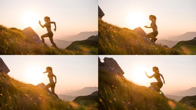 年轻的女运动员在日落时爬山
