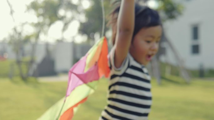 快乐的小男孩在草坪上玩风筝。