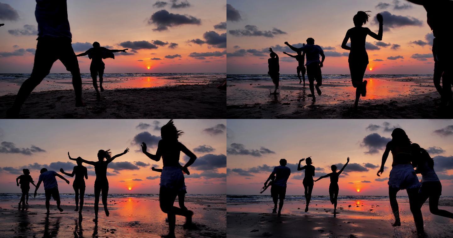 在沙滩奔跑的剪影海洋女性友谊日落