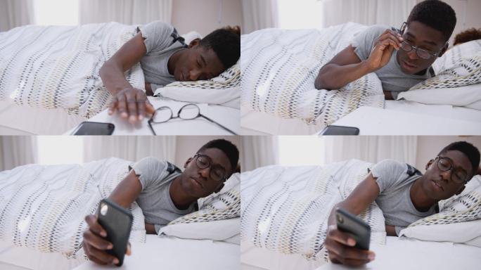 睡在床上的男子伸手关掉手机闹钟