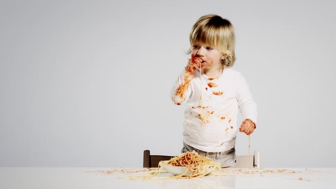 孩子在餐桌上吃着意大利面