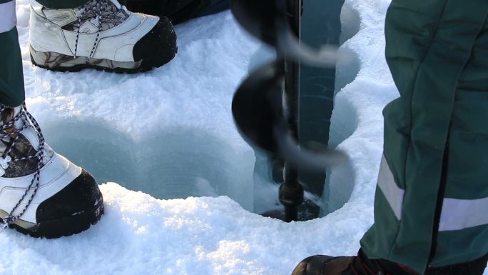 科学家在冰上钻洞采集北极的海水样本